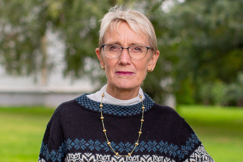 Portrettfoto av rektor Anne Borg. Hun står ute foran NTNUs hovedbygning.