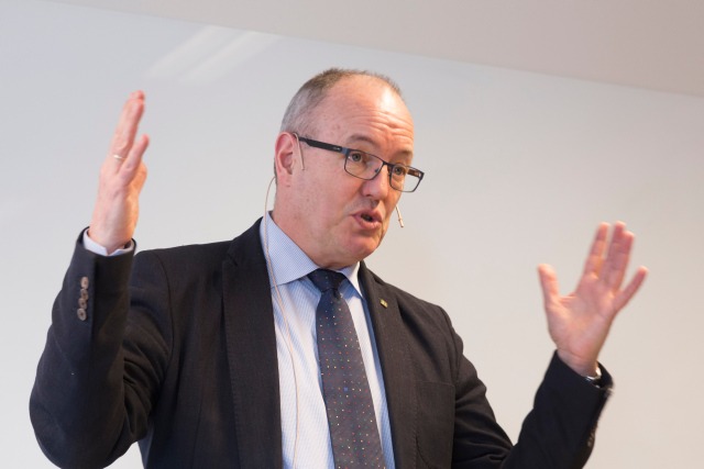 Gunnar Bovim snakker foran en forsamling, og gestikulerer