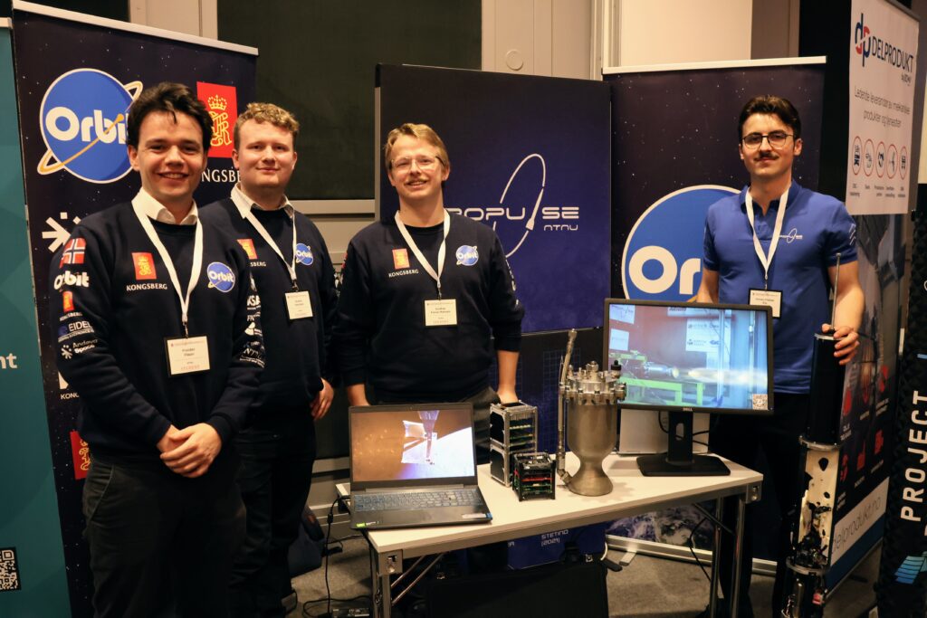Freider Engstrøm Fløan, Sindre Herstad og Gustav Fosse Hansen fra Orbit NTNU sammen med Simen Flåtter Flo fra Propulse stilte med stand på Forsvarskonferansen. Foto: Lars Bugge Aarset/NTNU