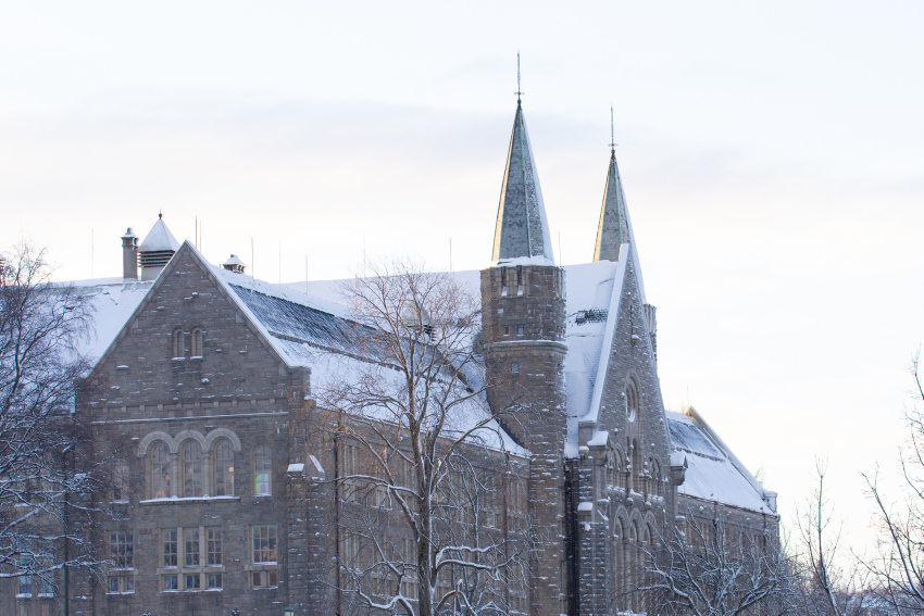 Hovedbygningen på Gløshaugen i Trondheim. Snø på taket og i tretoppene.