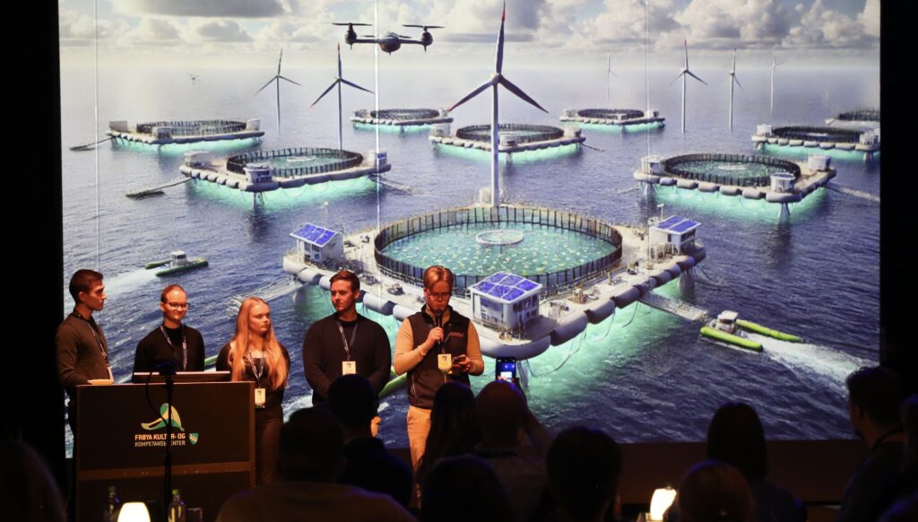 Gruppebilde med fem studenter på scenen på Brohodekonferansen med illustrasjon av offshoreanlegg i bakgrunnen.