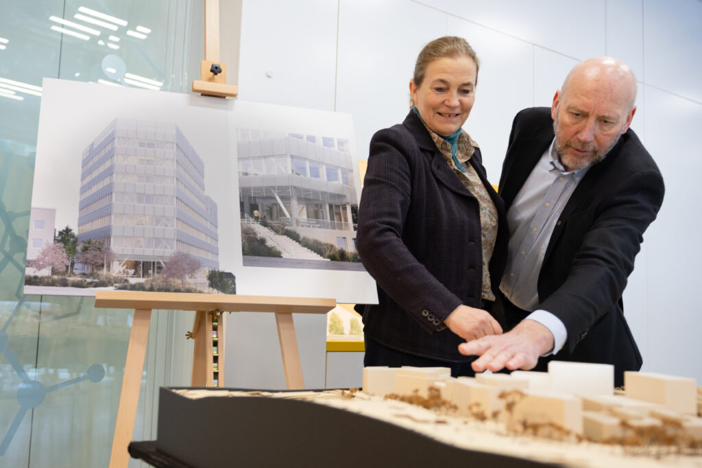 Tor Grande og Alexandra Bech Gjørv ser på modell av nybygg.